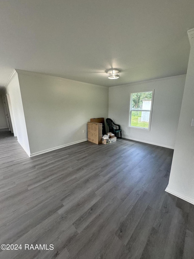 spare room featuring ornamental molding and dark wood-type flooring