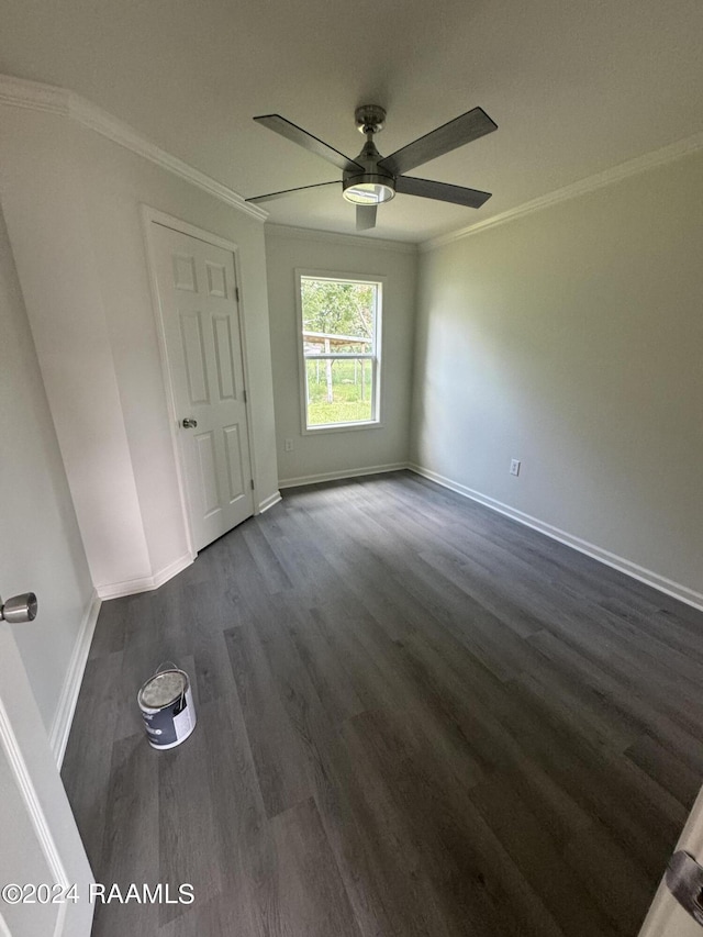 empty room featuring ceiling fan, ornamental molding, and dark hardwood / wood-style floors