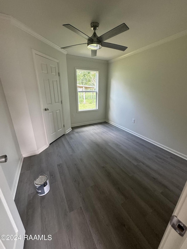 unfurnished room featuring crown molding, ceiling fan, and dark wood-type flooring