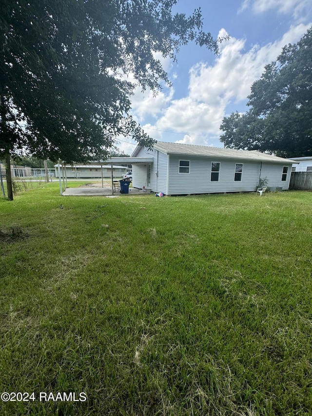 back of house with a yard and a patio area