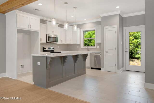 kitchen featuring appliances with stainless steel finishes, light hardwood / wood-style flooring, white cabinetry, and a wealth of natural light