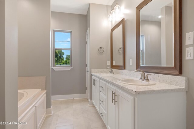 bathroom with dual vanity, a bathing tub, and tile patterned flooring