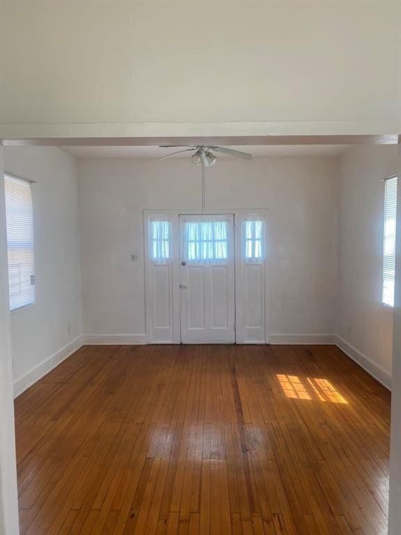 interior space featuring hardwood / wood-style flooring, baseboards, and a ceiling fan