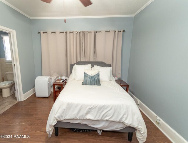 bedroom featuring ceiling fan, dark hardwood / wood-style floors, ornamental molding, and ensuite bath