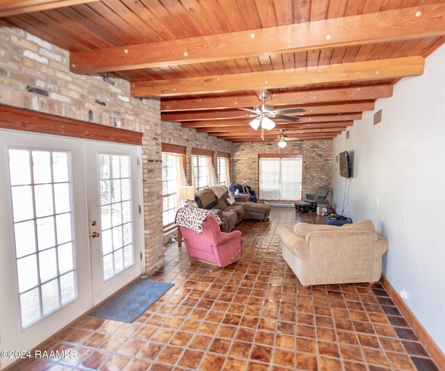 tiled living room featuring brick wall, ceiling fan, french doors, and plenty of natural light