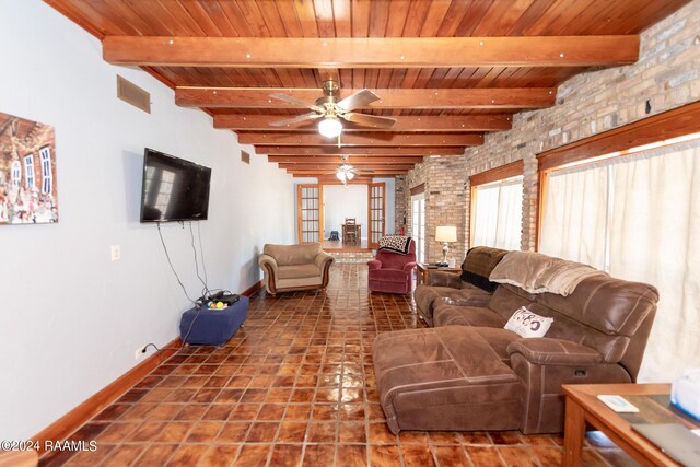 tiled living room featuring wood ceiling, brick wall, ceiling fan, and beamed ceiling