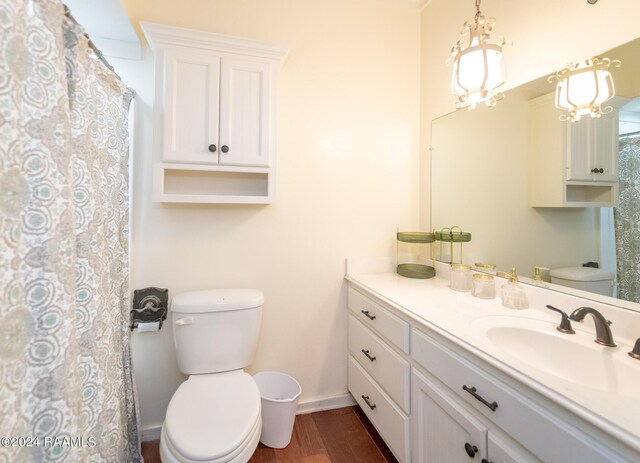 bathroom featuring wood-type flooring, toilet, vanity, and a chandelier