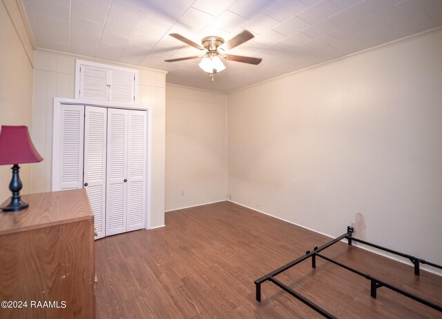 bedroom with a closet, ceiling fan, ornamental molding, and wood-type flooring