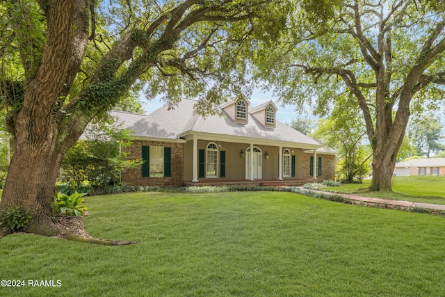 cape cod-style house featuring a front yard and covered porch