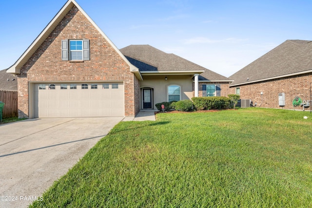 view of property featuring central AC, a garage, and a front lawn