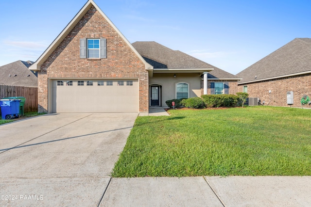 front of property with central AC unit, a garage, and a front yard