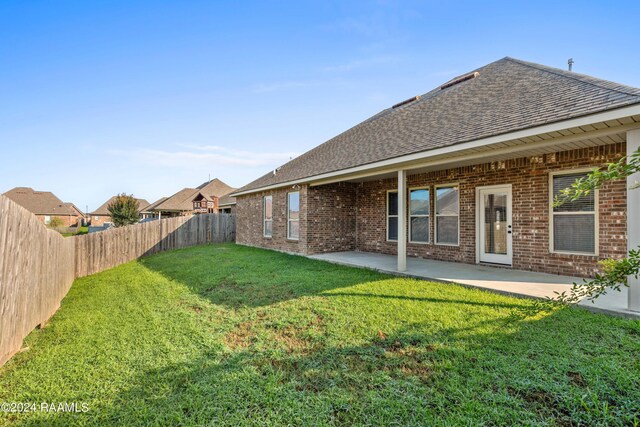 rear view of house with a lawn and a patio area