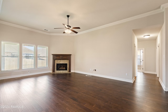 unfurnished living room featuring a high end fireplace, ceiling fan, dark wood-type flooring, and ornamental molding