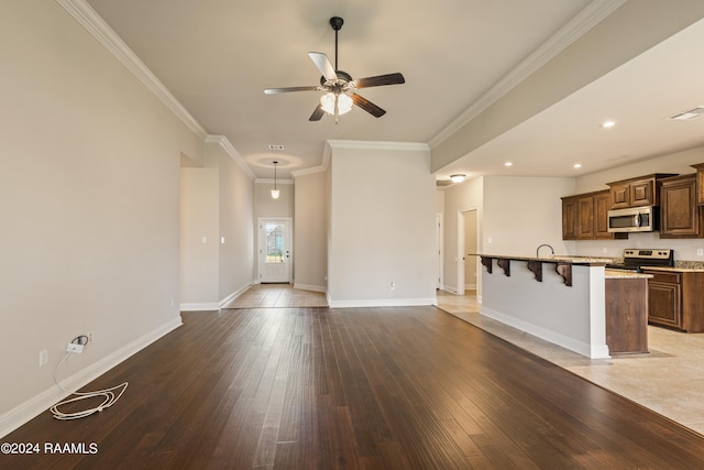 unfurnished living room featuring sink, ceiling fan, light hardwood / wood-style floors, and crown molding