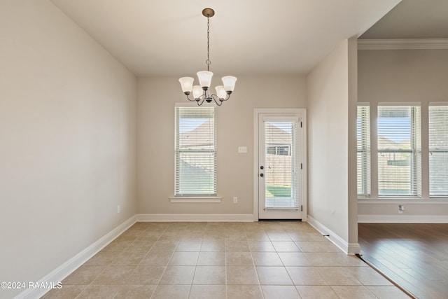 entryway with a notable chandelier, light tile patterned floors, and crown molding