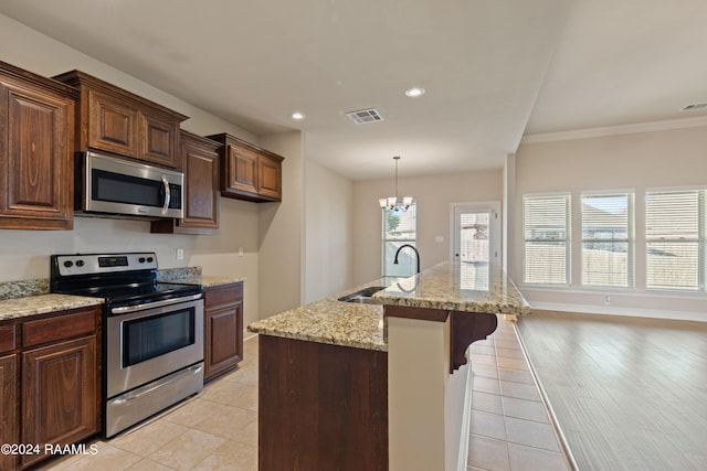 kitchen featuring appliances with stainless steel finishes, a kitchen island with sink, light hardwood / wood-style floors, and sink