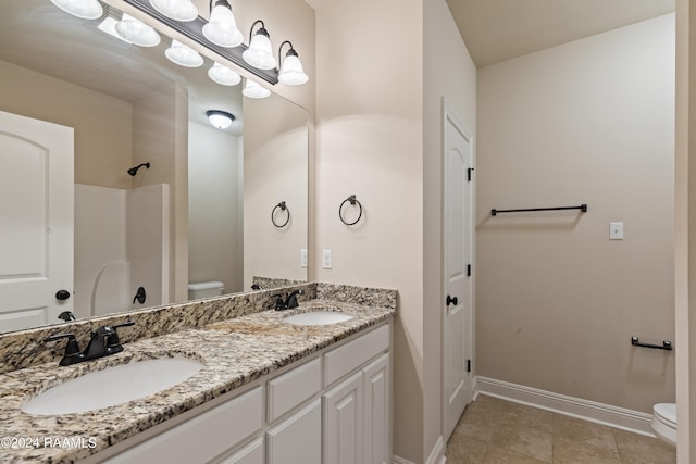 bathroom with tile patterned flooring, toilet, and double sink vanity