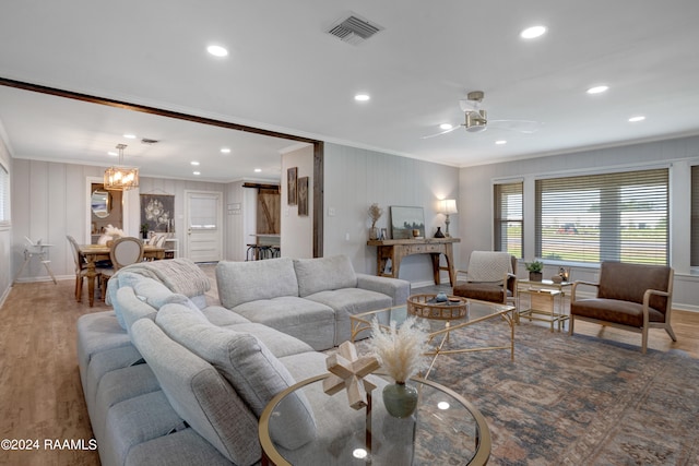 living room featuring hardwood / wood-style floors, ceiling fan, and crown molding