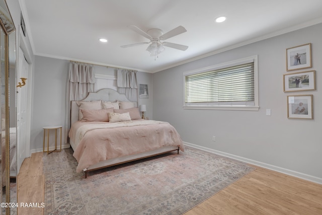 bedroom featuring ceiling fan, crown molding, and hardwood / wood-style flooring