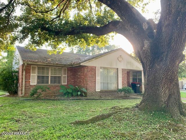 single story home featuring a front lawn