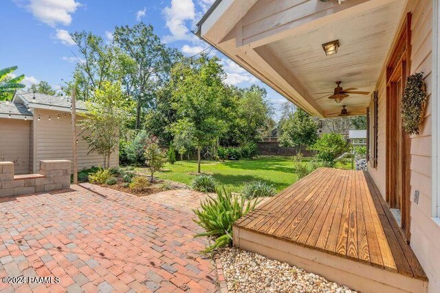 wooden terrace featuring a patio, ceiling fan, and a yard