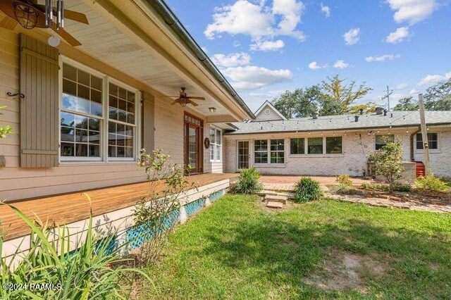 exterior space with a lawn and ceiling fan