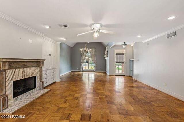 unfurnished living room with ceiling fan, dark parquet flooring, a tiled fireplace, and ornamental molding