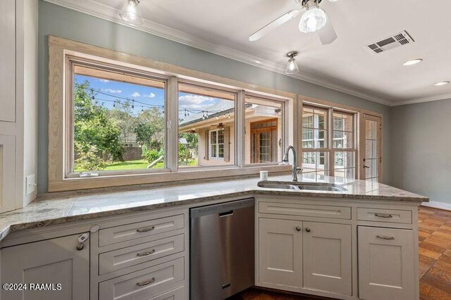 kitchen featuring light stone counters, dishwasher, ceiling fan, ornamental molding, and sink