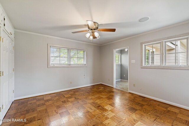 unfurnished room featuring a wealth of natural light, ceiling fan, light parquet floors, and crown molding