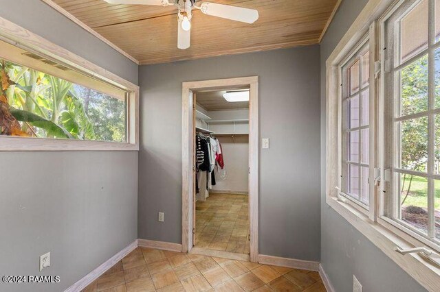 interior space with ceiling fan, a closet, multiple windows, and wooden ceiling