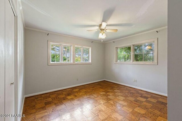 empty room featuring ceiling fan, parquet flooring, and crown molding