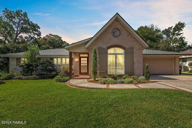 view of front of home featuring a garage and a yard