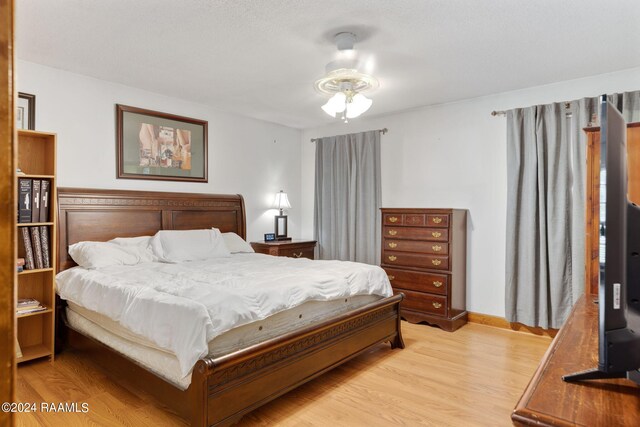 bedroom with light hardwood / wood-style flooring and ceiling fan