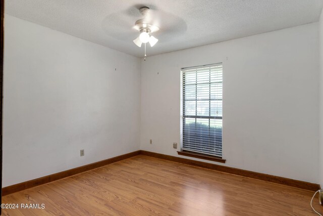 unfurnished room with light wood-type flooring, ceiling fan, and a textured ceiling