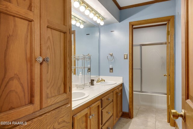 bathroom with shower / bath combination with glass door, vanity, ornamental molding, and tile patterned floors