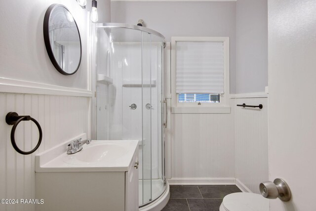 bathroom with tile patterned floors, toilet, an enclosed shower, and vanity