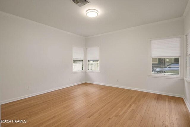 spare room with light wood-type flooring and ornamental molding