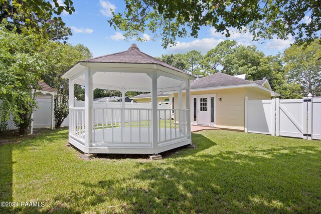 rear view of property with a gazebo and a yard