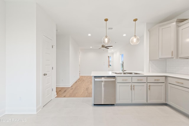 kitchen featuring a peninsula, light countertops, ceiling fan, dishwasher, and a sink