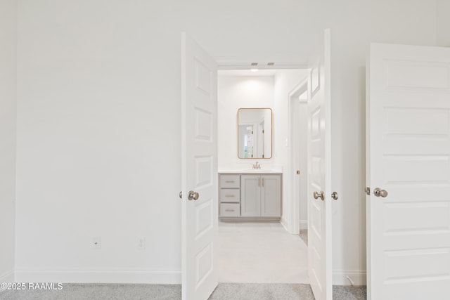 hall with baseboards and a sink
