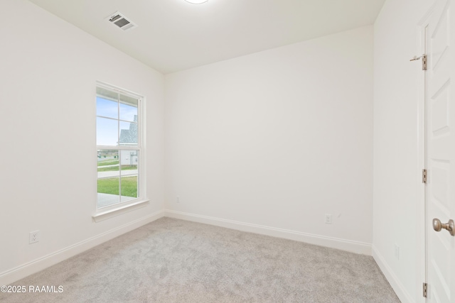 spare room featuring carpet flooring, visible vents, and baseboards