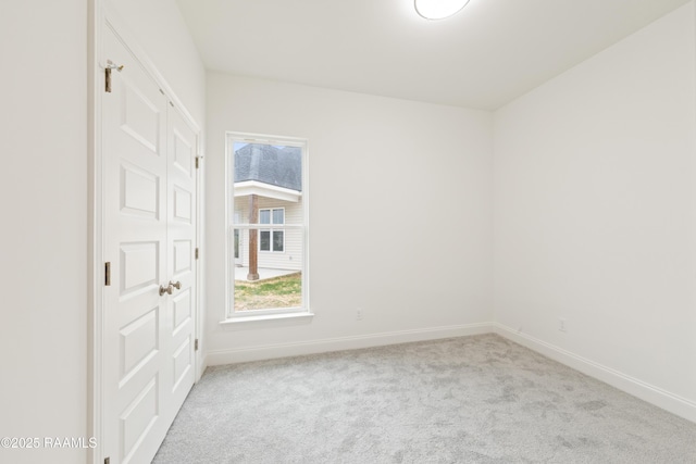 carpeted empty room with baseboards