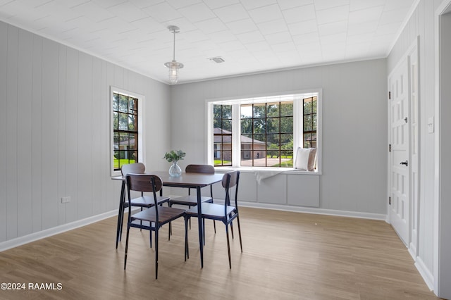 dining area featuring a healthy amount of sunlight, baseboards, visible vents, and wood finished floors
