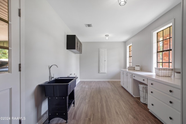 bathroom with baseboards, visible vents, and wood finished floors