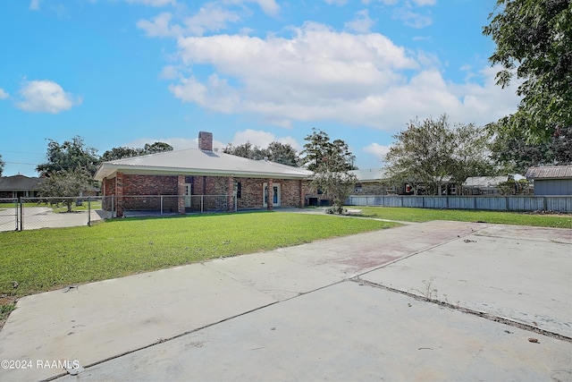 exterior space with a yard, brick siding, a chimney, and fence