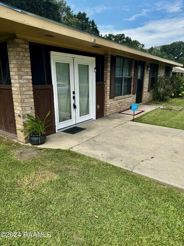 back of house featuring a patio area and a lawn