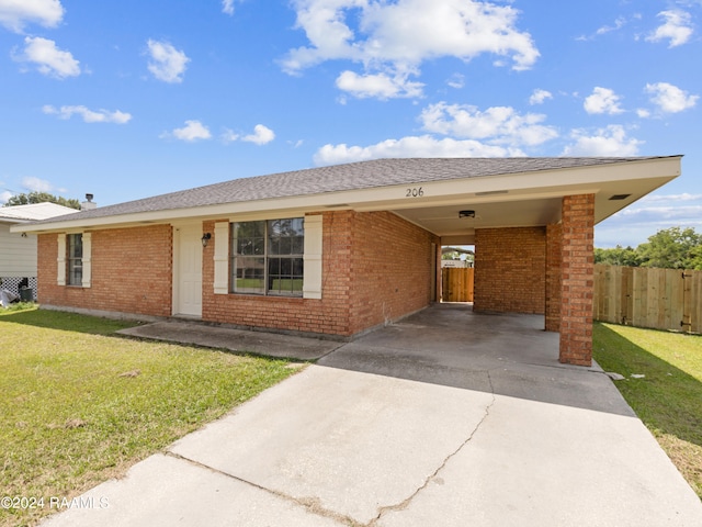 single story home featuring a carport and a front lawn