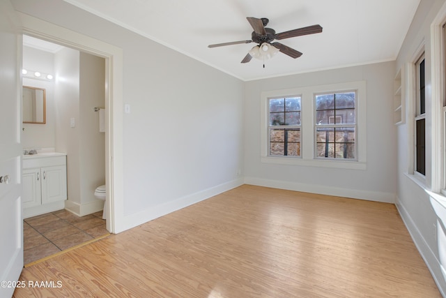 unfurnished room featuring ceiling fan, crown molding, light hardwood / wood-style floors, and sink