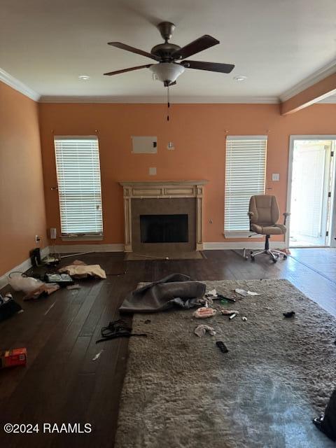 unfurnished living room featuring hardwood / wood-style flooring, crown molding, and ceiling fan