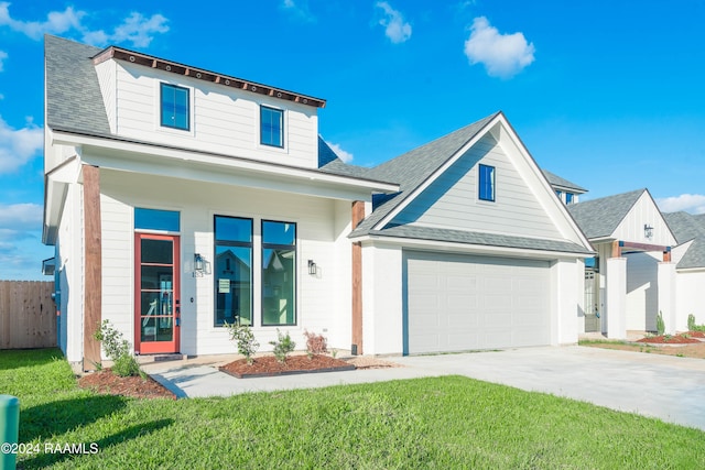 view of front facade with covered porch, a garage, and a front yard